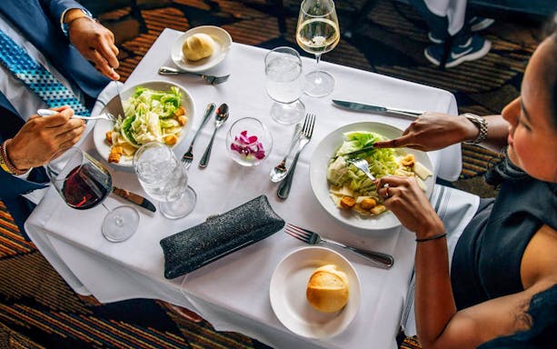 Guests dining on Odyssey Lake Michigan Dinner Cruise with salads and wine.