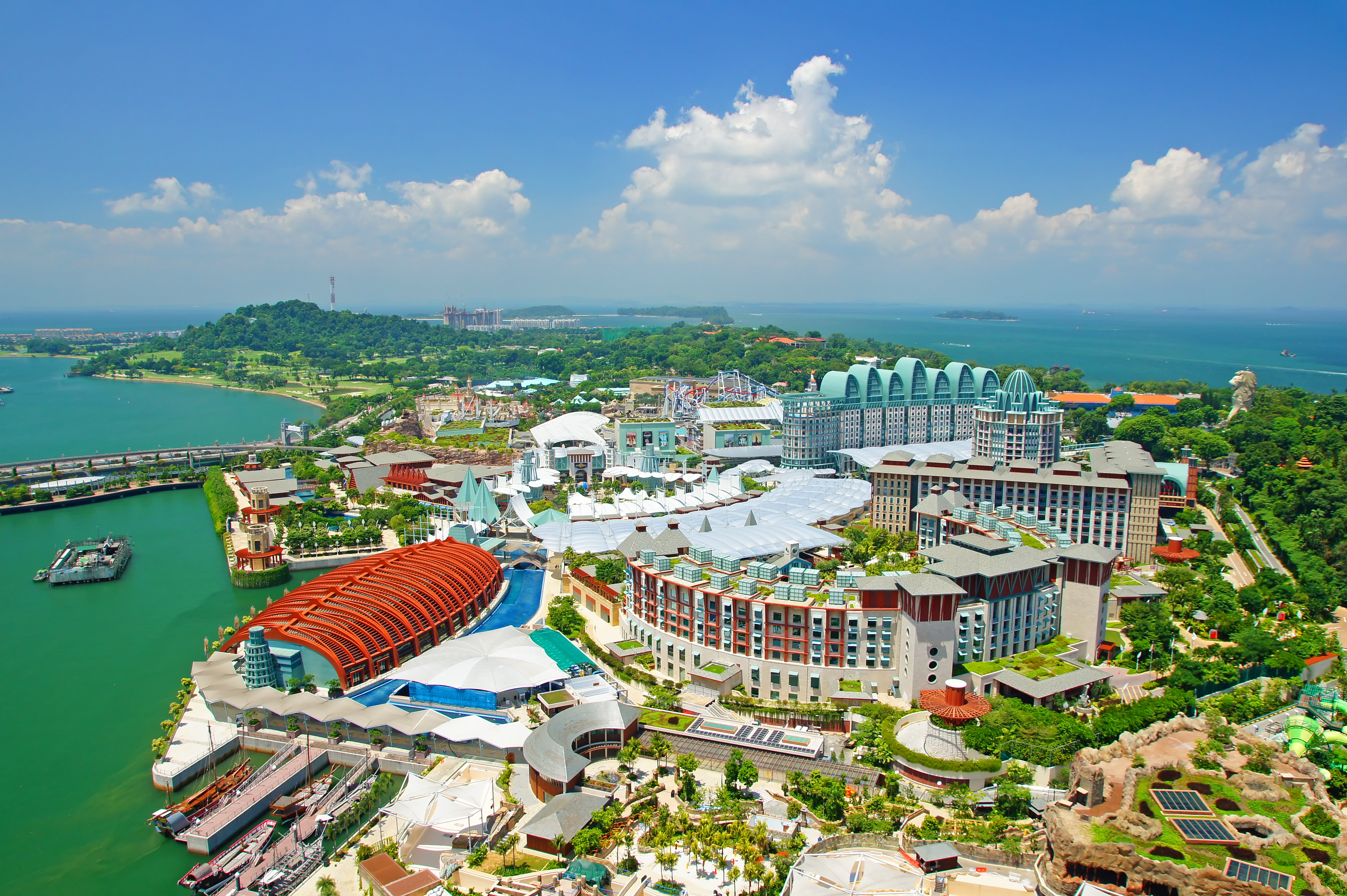 Aerial view of Sentosa Island, showcasing resorts, attractions, and lush greenery.