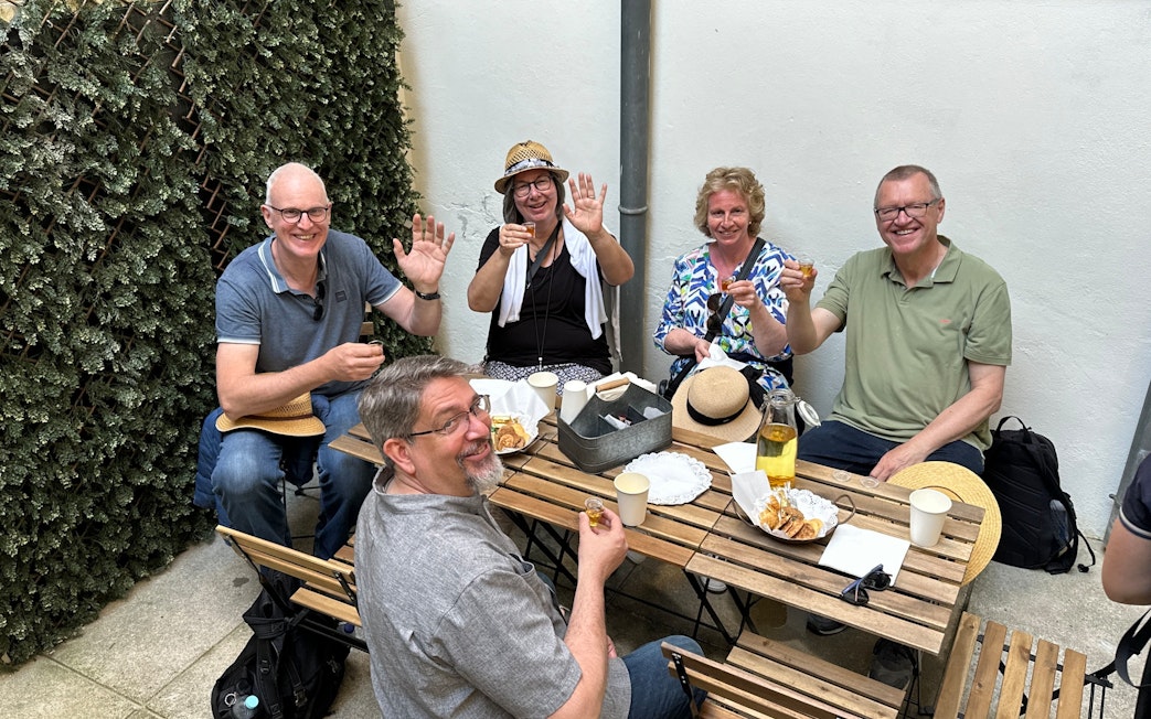 Tourists enjoying a food break with drinks and snacks at an outdoor cafe.