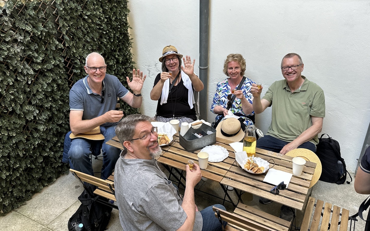 Tourists enjoying a food break with drinks and snacks at an outdoor cafe.
