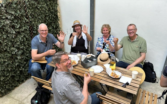 Tourists enjoying a food break with drinks and snacks at an outdoor cafe.