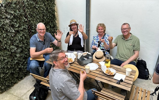 Tourists enjoying a food break with drinks and snacks at an outdoor cafe.