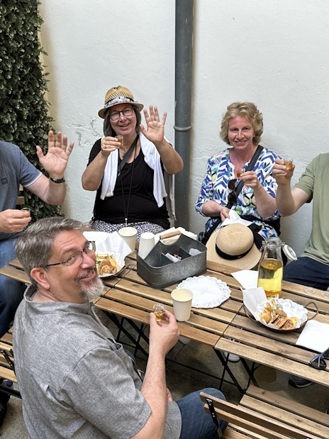 Tourists enjoying a food break with drinks and snacks at an outdoor cafe.