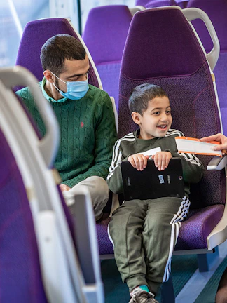 Train staff checking ticket of seated passengers.