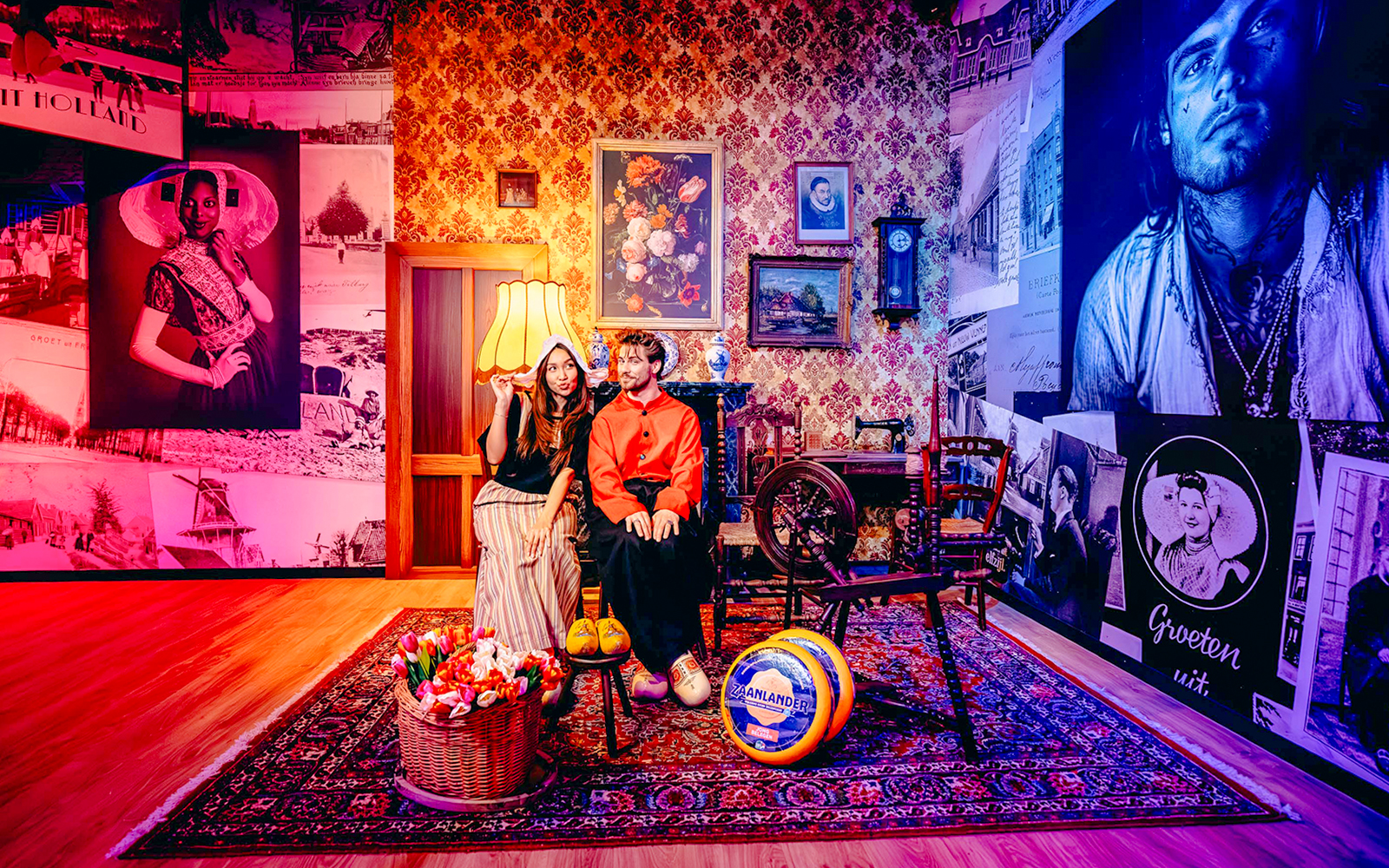 Guests in traditional Dutch attire in a Holland-themed room with tulips and cheese.
