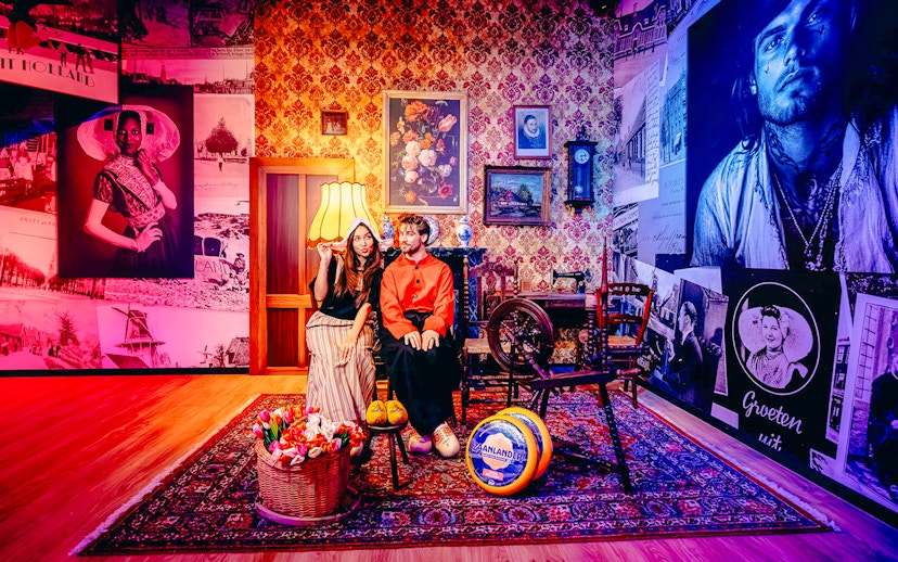 Guests in traditional Dutch attire in a Holland-themed room with tulips and cheese.