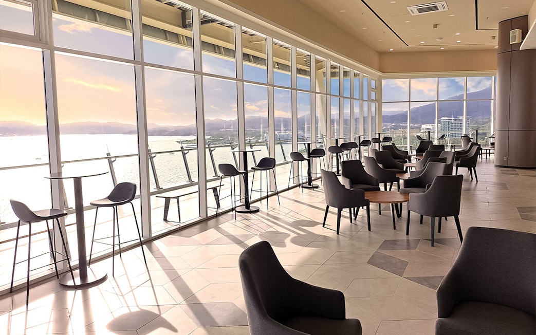 Spacious lounge with panoramic views of the sea and mountains at Maha Tower, Malaysia.