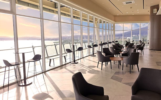 Spacious lounge with panoramic views of the sea and mountains at Maha Tower, Malaysia.