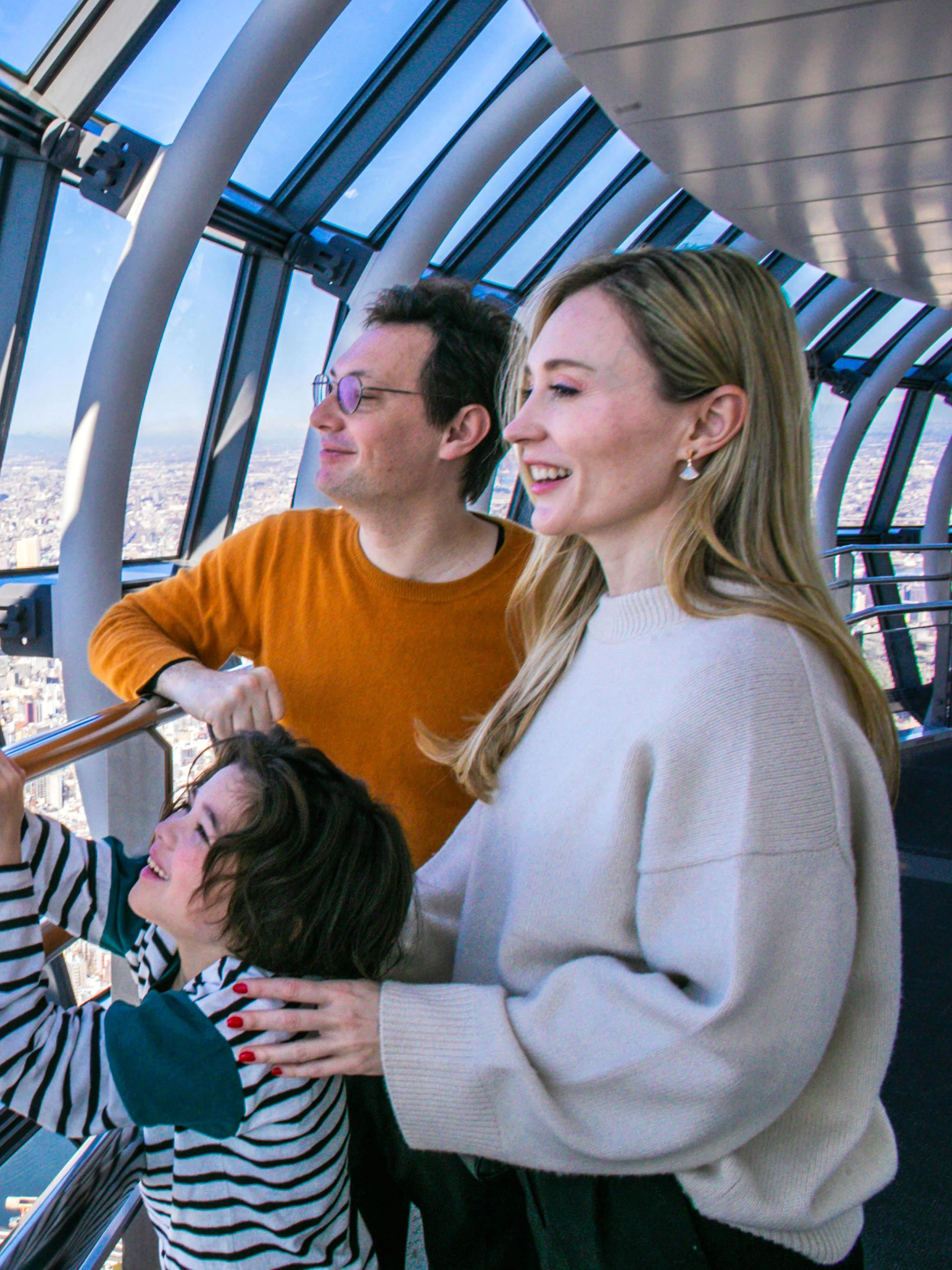Family enjoying panoramic view from Tokyo Skytree observation deck.