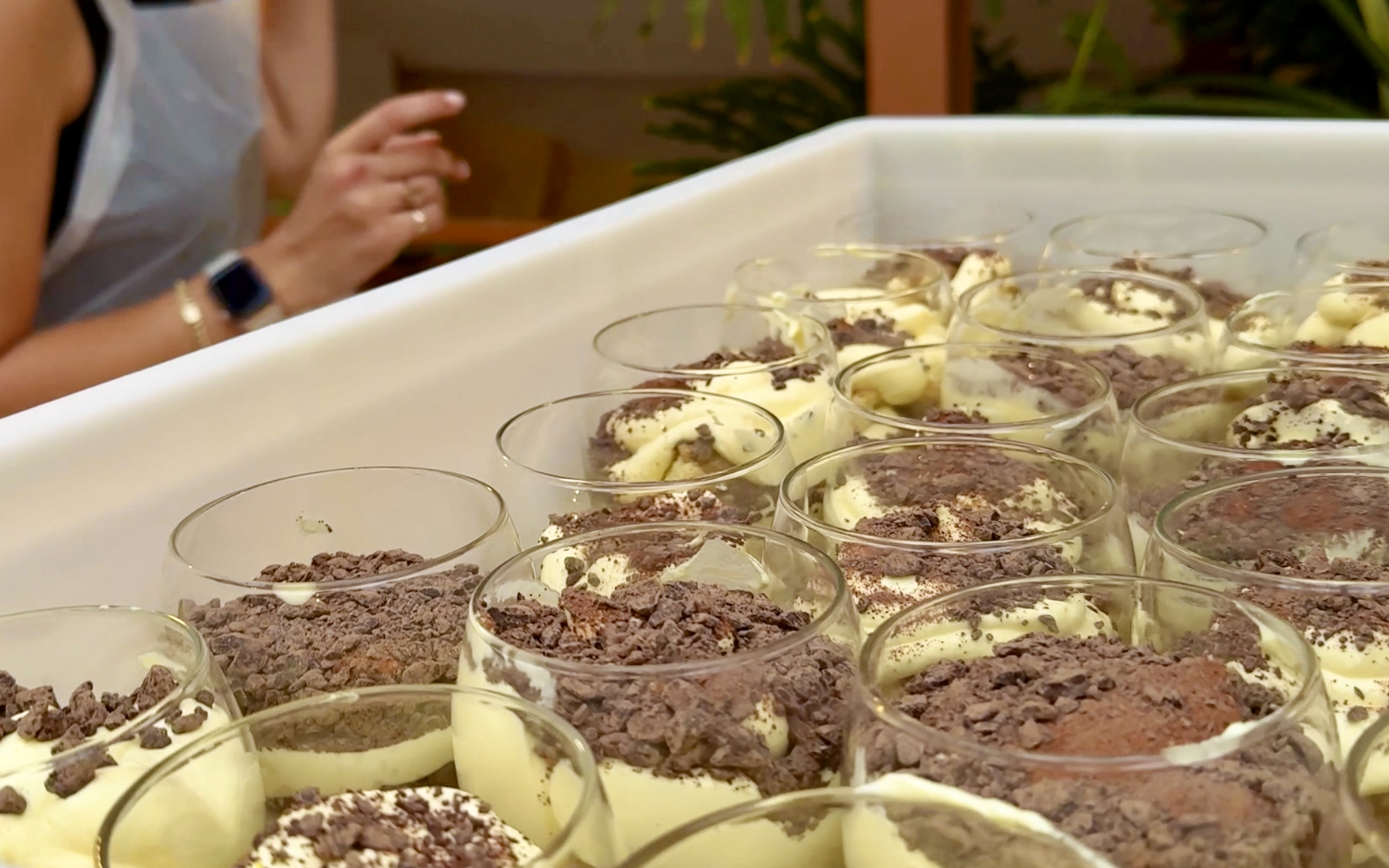 Tiramisu preparation at a cooking class in Siena with chocolate shavings.