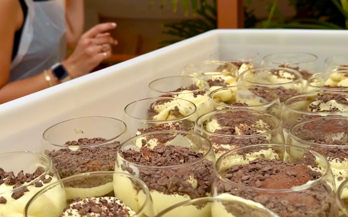 Tiramisu preparation at a cooking class in Siena with chocolate shavings.