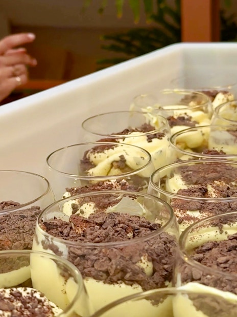 Tiramisu preparation at a cooking class in Siena with chocolate shavings.