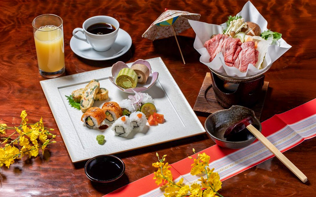 Sushi and traditional Japanese meal with drinks on a table, part of Nagano tour experience.