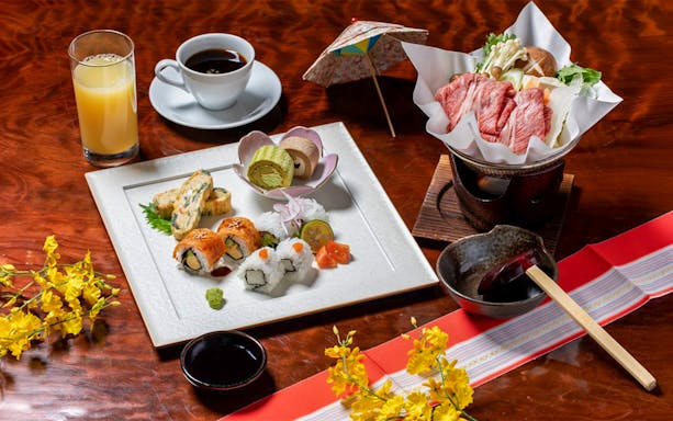 Sushi and traditional Japanese meal with drinks on a table, part of Nagano tour experience.