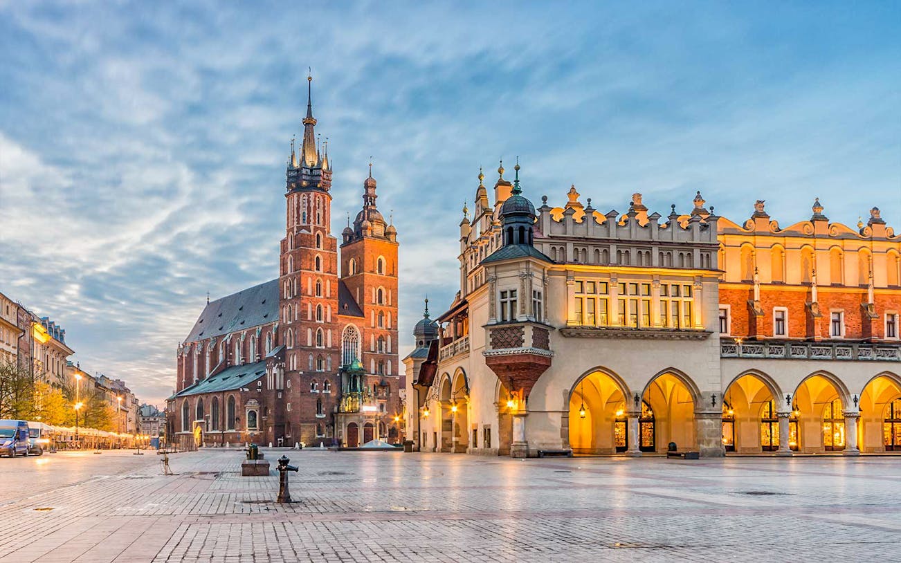 St. Mary's Church and Cloth Hall in Krakow's Main Square at dusk.