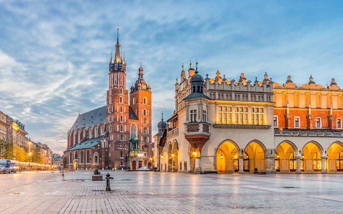St. Mary's Church and Cloth Hall in Krakow's Main Square at dusk.