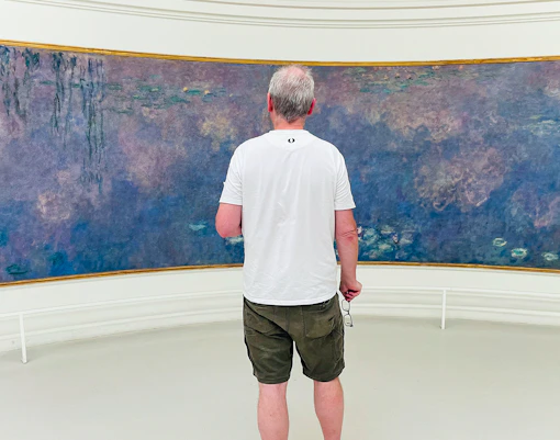 Man viewing paintings in Orangerie Museum, Paris.