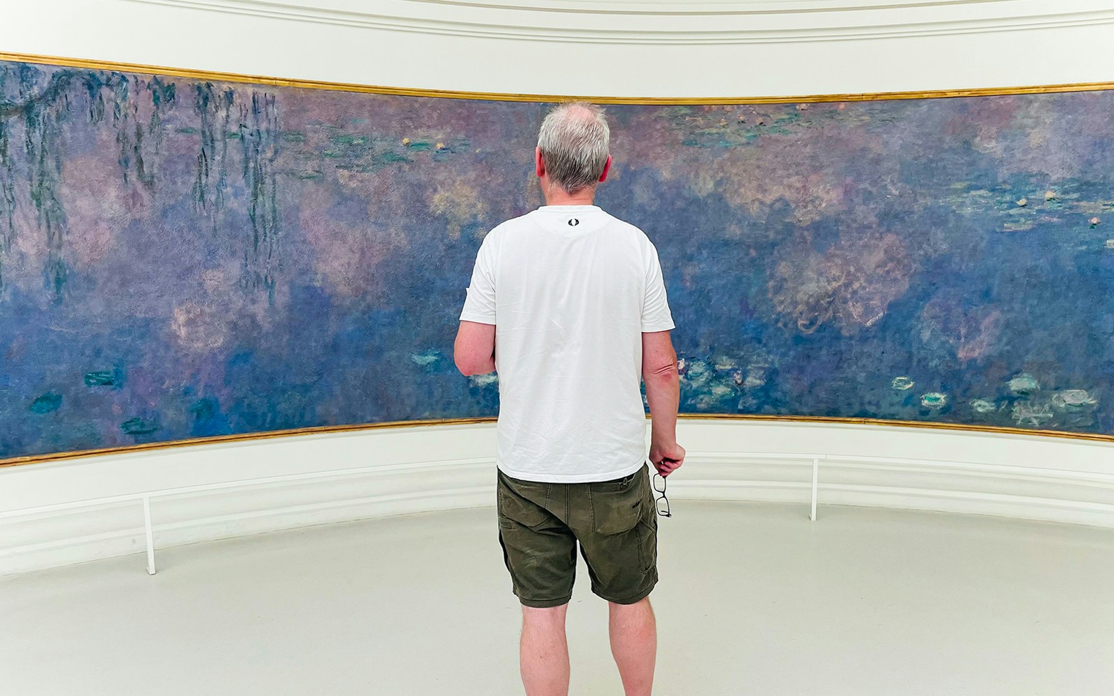 Man viewing paintings in Orangerie Museum, Paris.