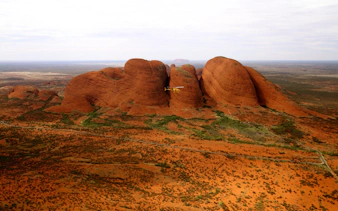 Aerial view of Kata Tjuta rock formations with a helicopter in flight, Northern Territory, Australia.