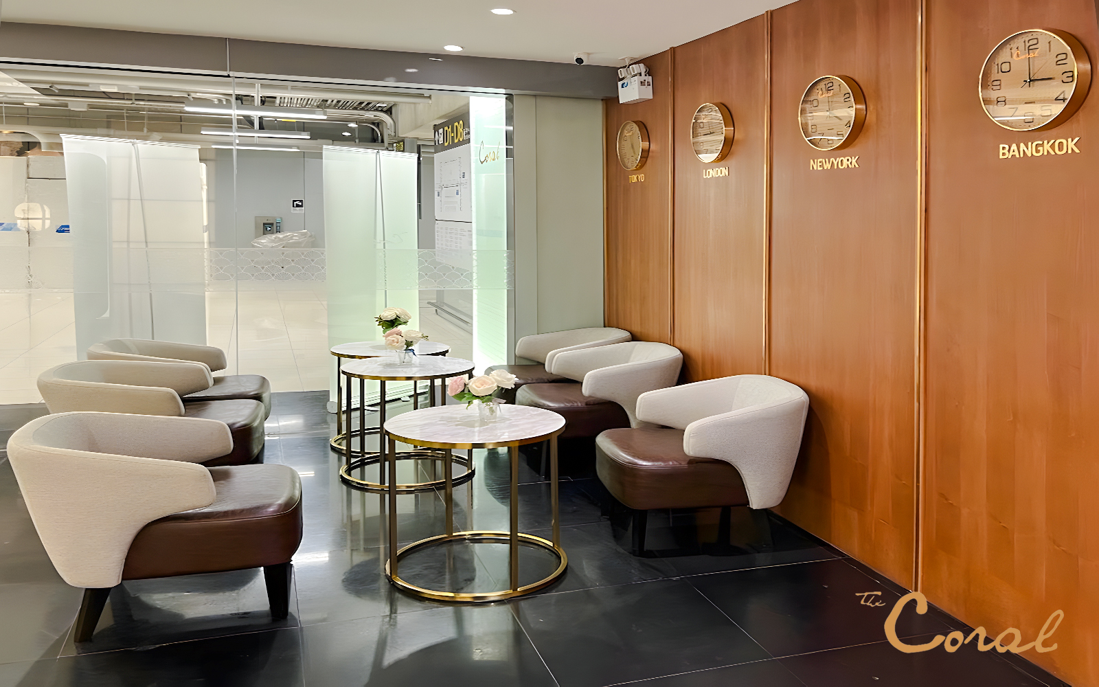 Business class lounge seating area with clocks showing global times, Coral Lounge, Bangkok Airport.