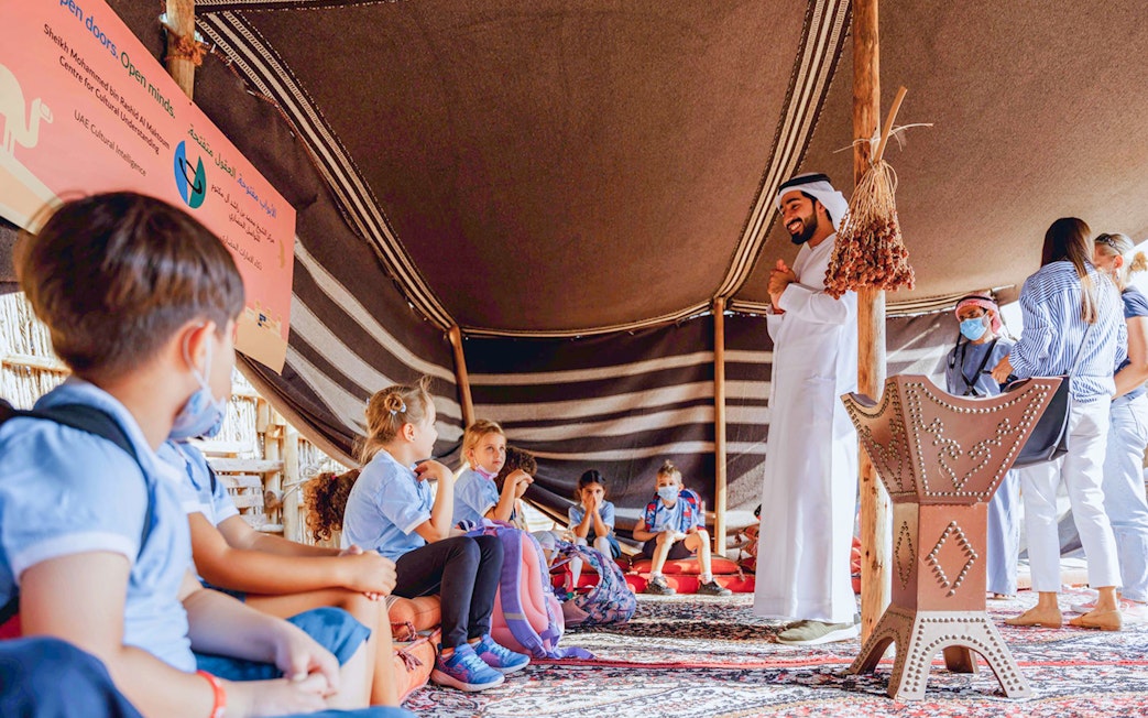 Children learning in a traditional tent during a cultural tour in Dubai.