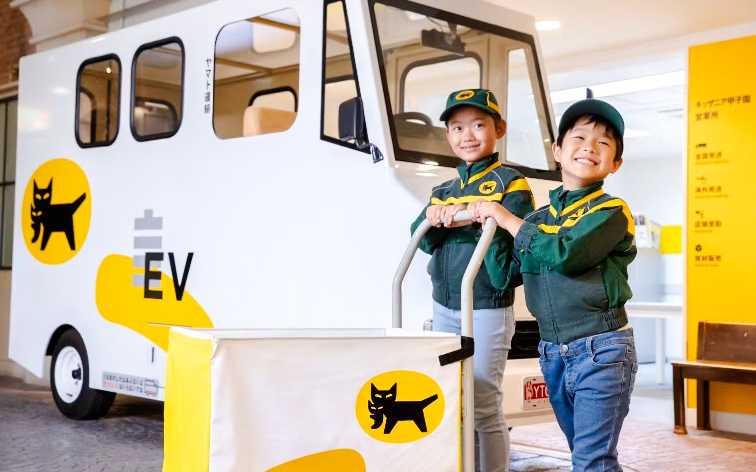 Children in delivery uniforms with electric vehicle at KidZania Osaka Koshien.