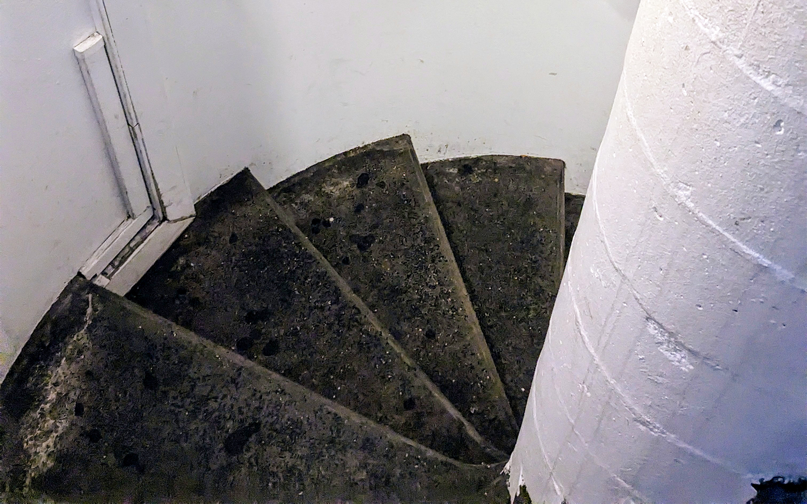Spiral staircase in a historic building, showcasing worn stone steps.