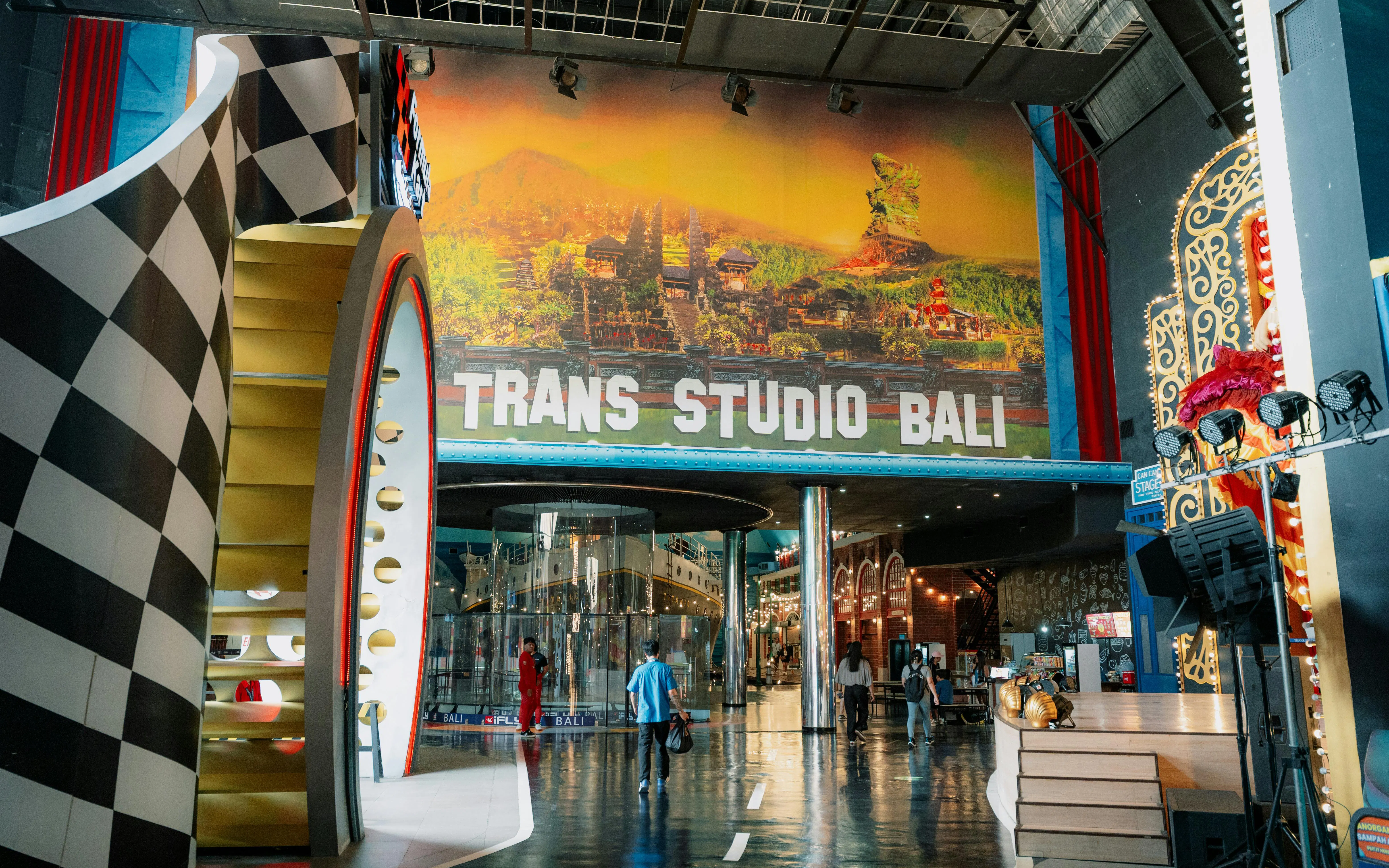 Trans Studio Bali entrance with colorful decor and visitors exploring the indoor theme park.