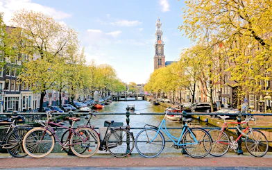 Bicycles parked on a bridge over a canal near Amsterdam Centraal Station.