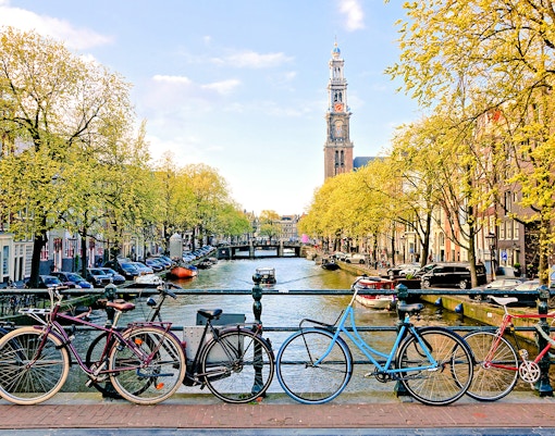 Bicycles parked on a bridge over a canal near Amsterdam Centraal Station.