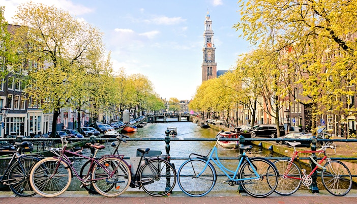 Bicycles parked on a bridge over a canal near Amsterdam Centraal Station.