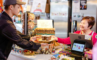 Vendor serving coffee samples at Pike Place Market during chef-guided food tour.