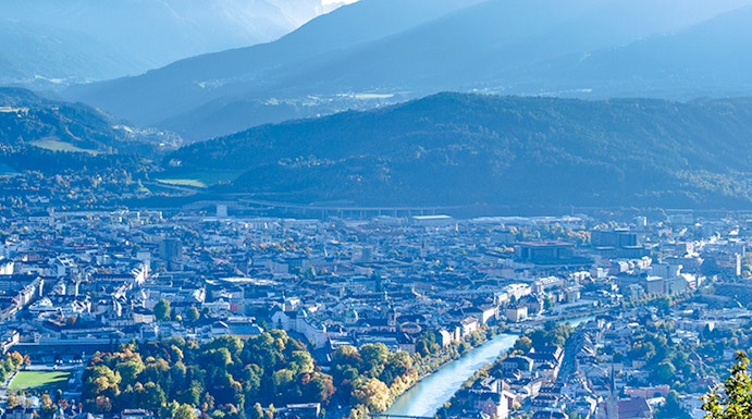 Hungerburg view of Innsbruck cityscape with mountains and river.