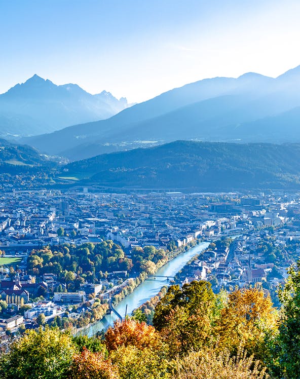 Hungerburg view of Innsbruck cityscape with mountains and river.