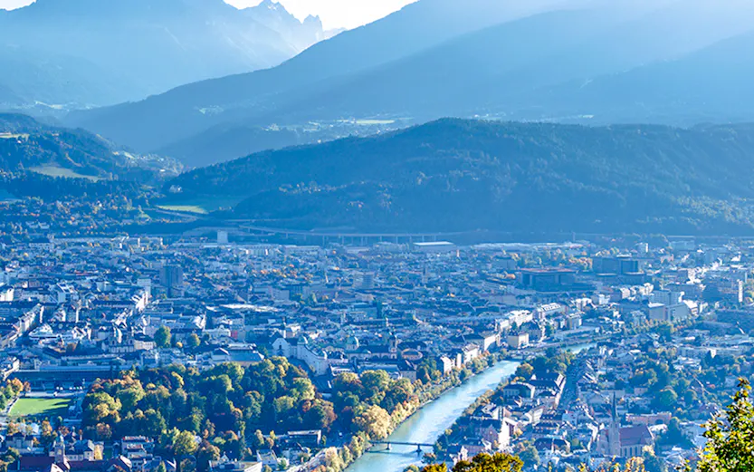Hungerburg view of Innsbruck cityscape with mountains and river.
