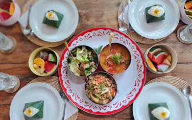 Traditional Thai meal with curry, vegetables, and fruit served on a wooden table in Krabi.