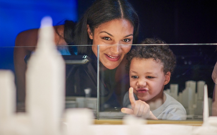Child and adult exploring Melbourne Skydeck model at Eureka Tower.
