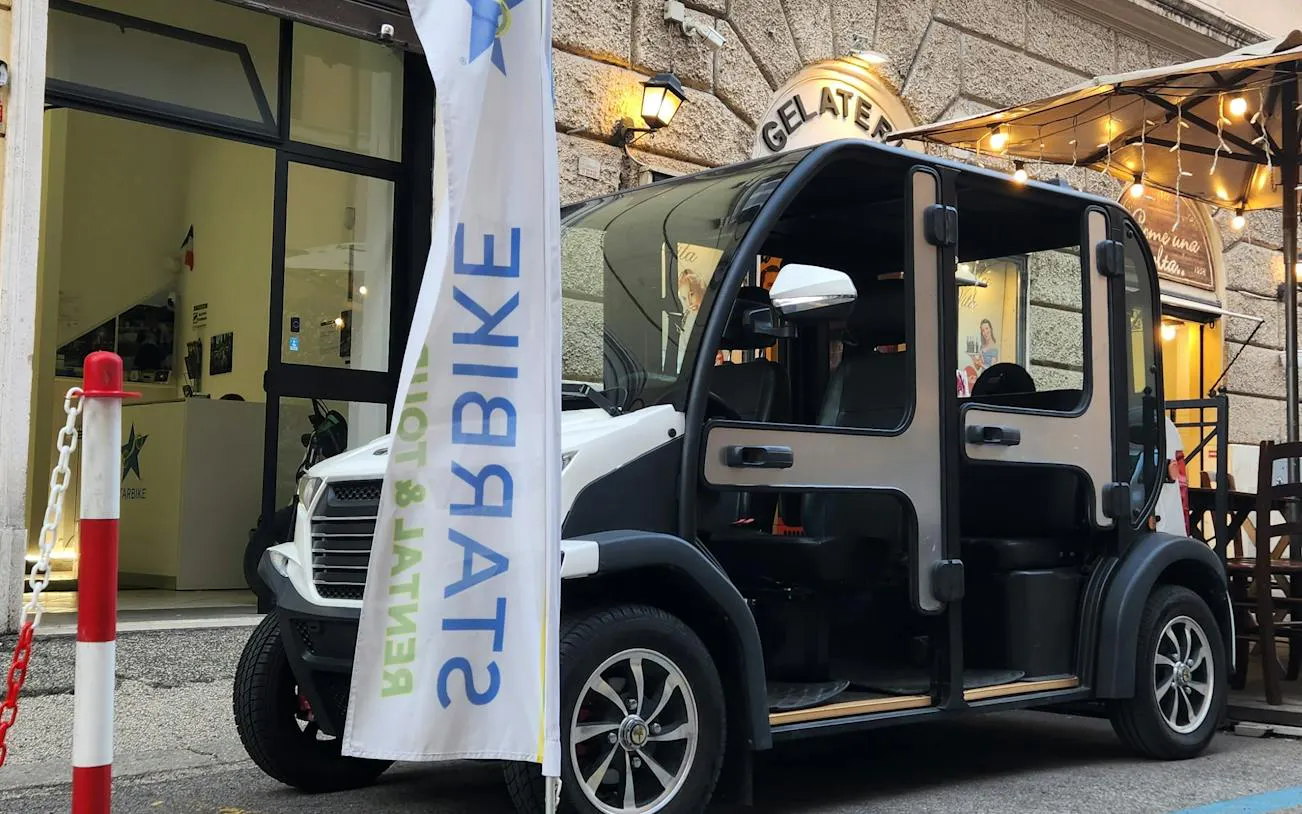 Private golf cart parked outside a gelateria in Rome city center.