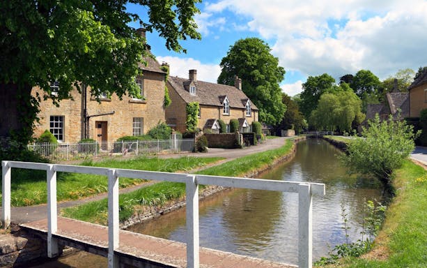 Cotswolds village view with stone cottages and a canal, ideal for a lunch tour.