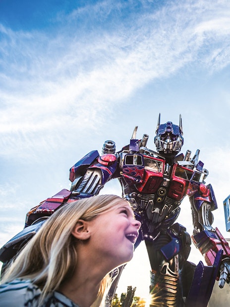 Little girl looking up at Transformers characters at Universal Studios Orlando.