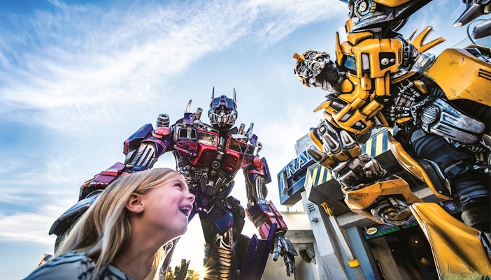 Little girl looking up at Transformers characters at Universal Studios Orlando.