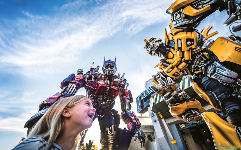 Little girl looking up at Transformers characters at Universal Studios Orlando.