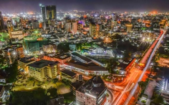 Dar es Salaam cityscape at night with illuminated buildings and streets, viewed from above.