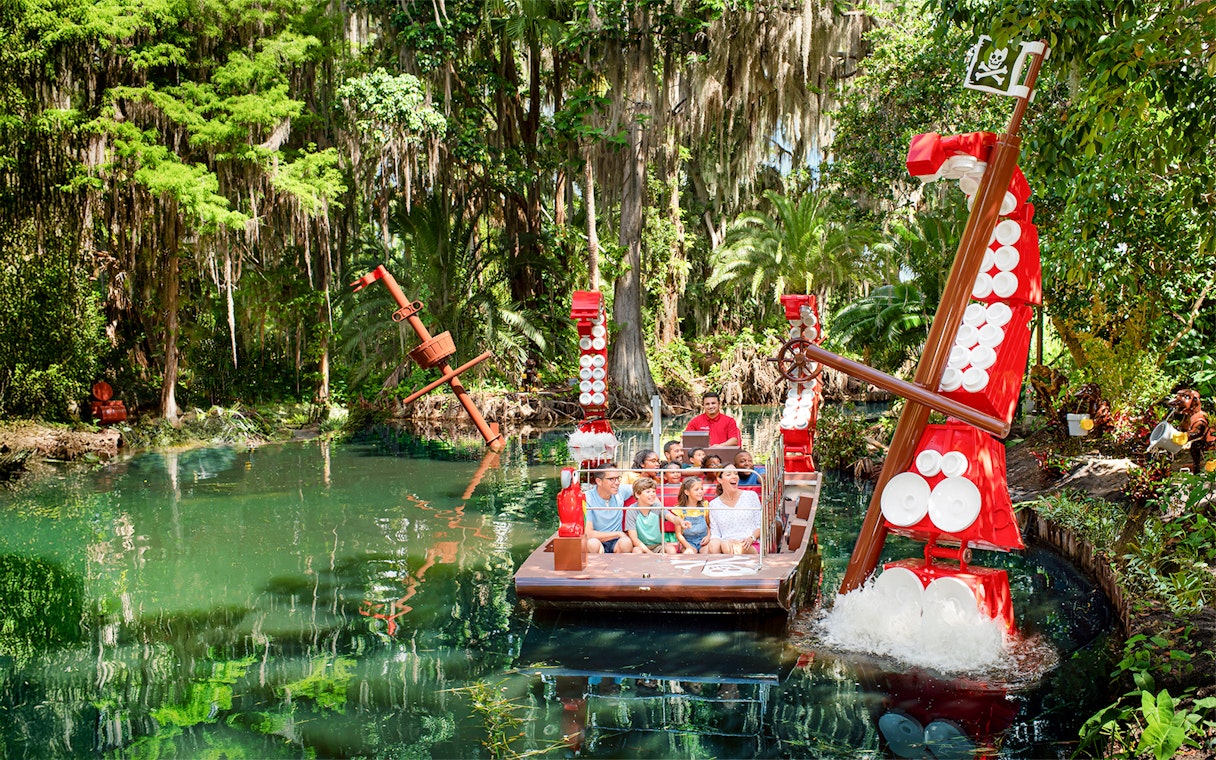 Pirate-themed boat ride at Pirate River Quest, LEGOLAND Florida, surrounded by lush greenery.