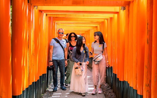 Visitors walking through Fushimi Inari Shrine's torii gates on Kyoto day tour from Osaka Namba.