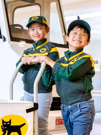 Children in delivery uniforms at KidZania Koshien, Tokyo, participating in a role-play activity.