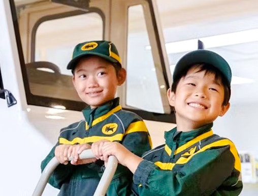 Children in delivery uniforms at KidZania Koshien, Tokyo, participating in a role-play activity.