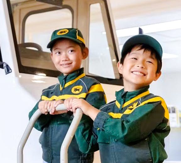 Children in delivery uniforms at KidZania Koshien, Tokyo, participating in a role-play activity.