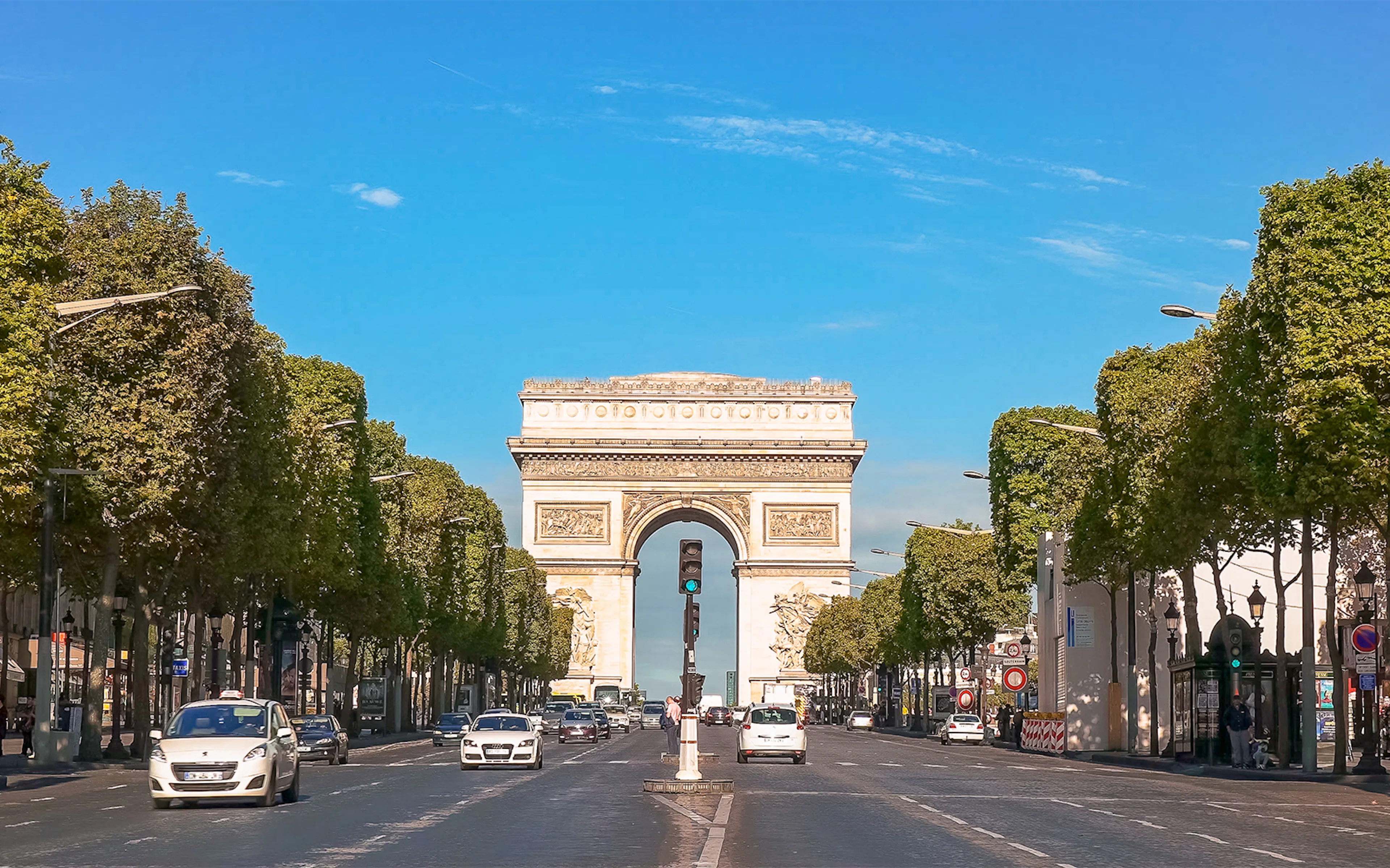 Arc de Triomphe viewed from Champs Elysées, Paris, with cars on the avenue.