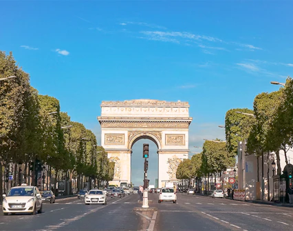 Arc de Triomphe viewed from Champs Elysées, Paris, with cars on the avenue.